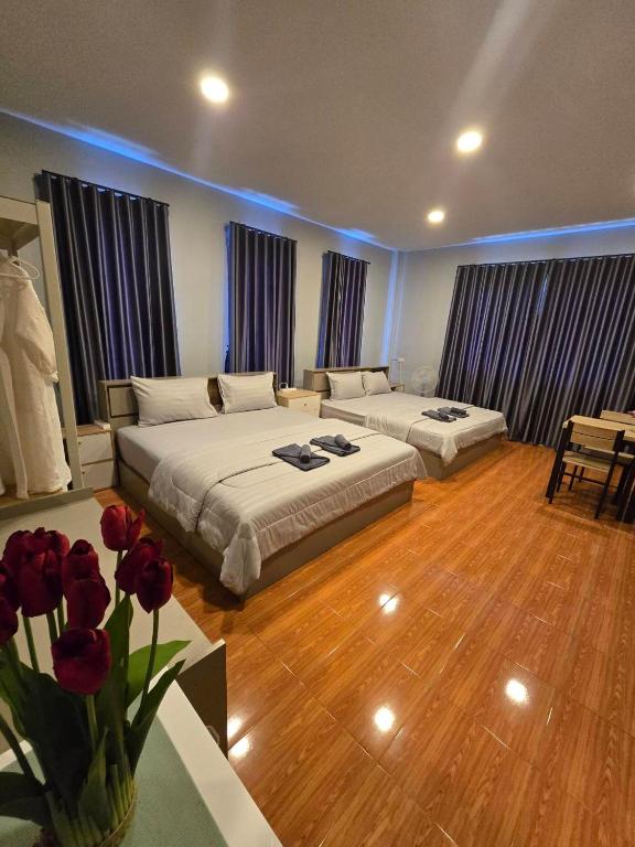 a bedroom with two beds and a table with flowers at Chaba4 in Ban Nong Bua Noi