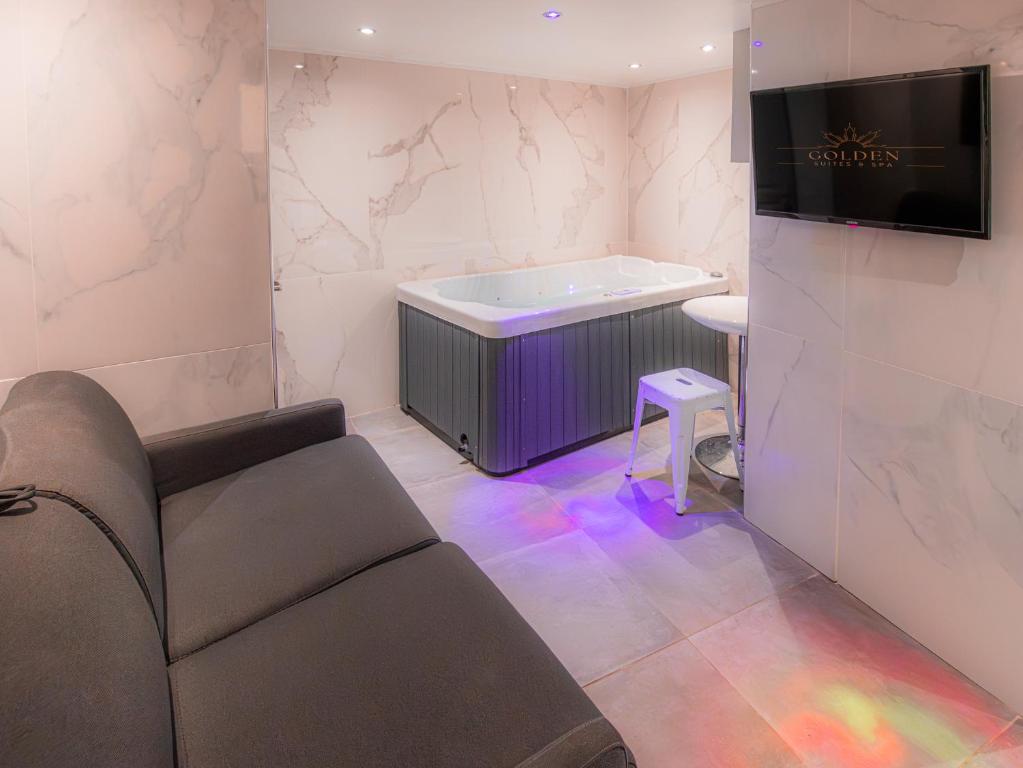 - un salon avec un canapé et une baignoire dans l'établissement Le Ronali - Jacuzzi, à Manosque