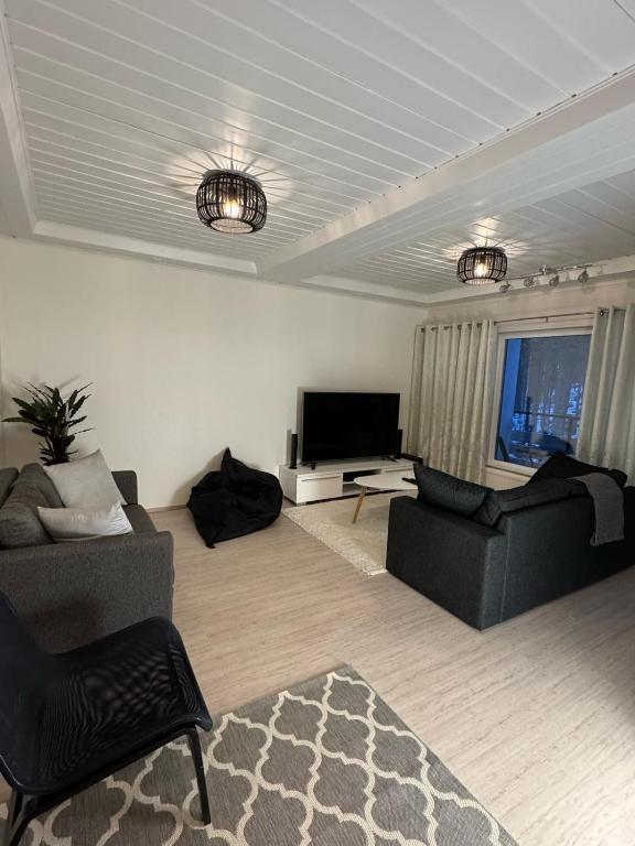 a living room with two couches and a flat screen tv at Ketunpesä Puijolla in Kuopio