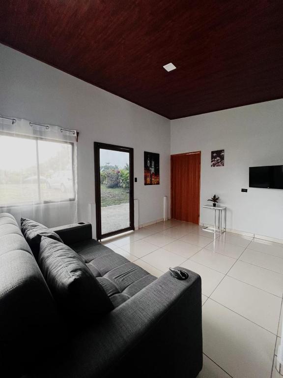 a living room with a couch and a large window at Teyú Green Cottage in Cuatro Esquinas