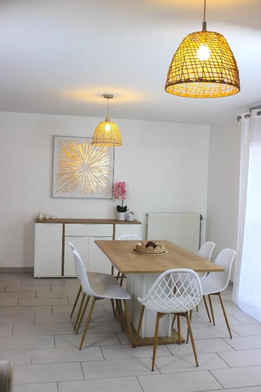 une salle à manger avec une table et des chaises blanches dans l'établissement Appartement l'esprit de Lourdes, proche sanctuaire et gare, vue sur le château, à Lourdes