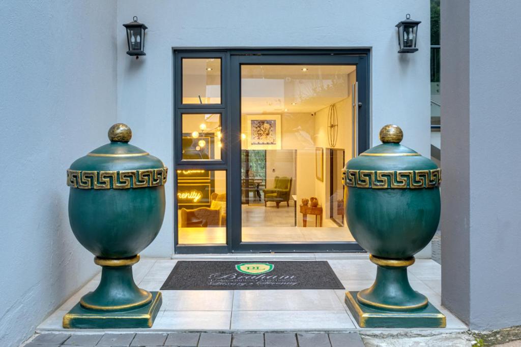twee grote groene vazen voor een gebouw bij Braham Lodge - The Octave in Johannesburg