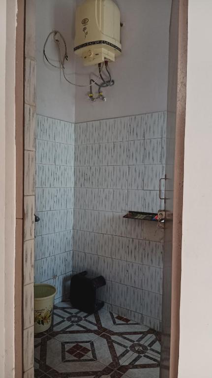 a bathroom with a toilet and a light on the wall at New sharma homestay in Prayagraj