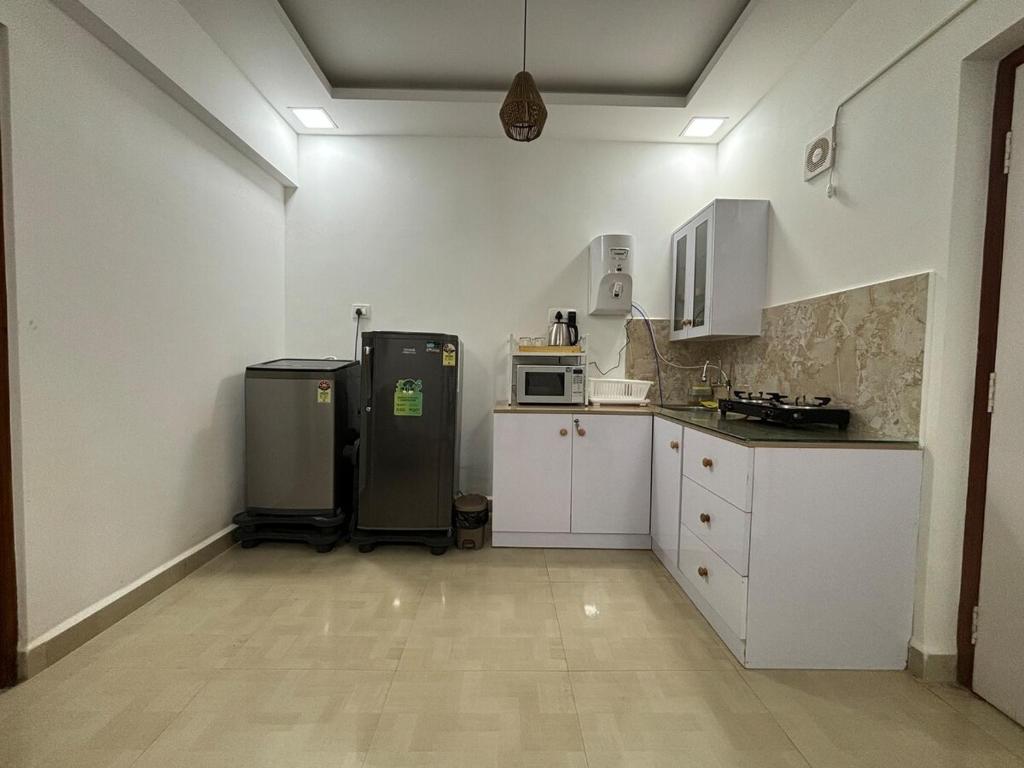 a kitchen with white cabinets and a refrigerator at Vihaa - Boutique Stay in Vagator