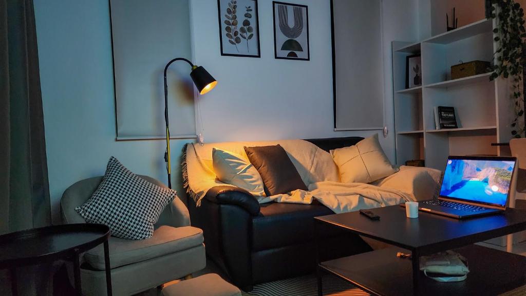 Una sala de estar con un sofá con una computadora portátil encima. en Modern Zen Houses Soft mattress 900 Mbps 10min beach, en Ko Pha Ngan