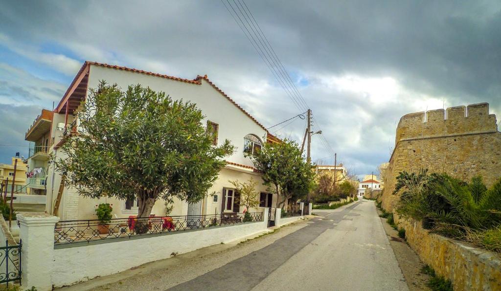 an empty street in a town with a building and trees at Venezian Castle House in Kissamos