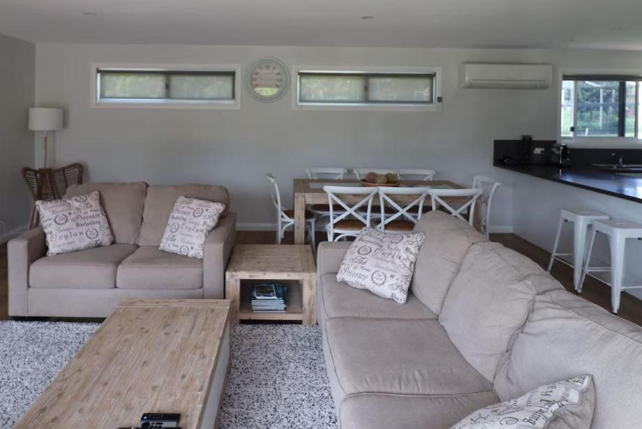 a living room with a couch and a table at 19 Blackwood Drive in Mallacoota
