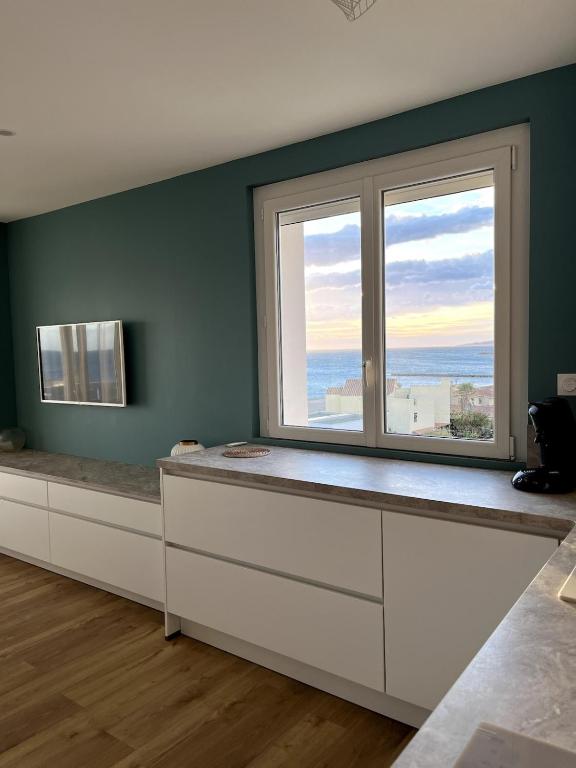 Cette chambre dispose d'une grande fenêtre offrant une vue sur l'océan. dans l'établissement Le Miramar La Vue, à Saint Cyprien Plage