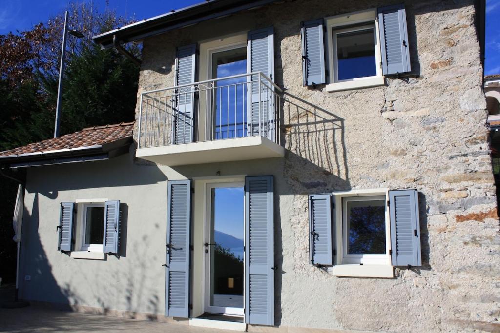 a building with blue shuttered windows and a balcony at Casa San Martino in Arizzano