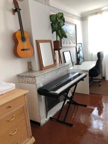 een woonkamer met een piano en een gitaar bij Proximité Palais des Festivals in Cannes