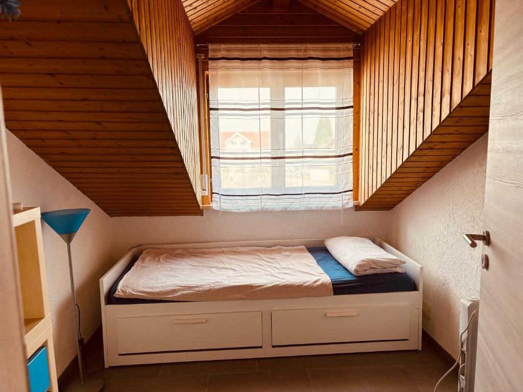 a small bed in a room with a window at Ferienwohnung Alpenblick in Pürgen