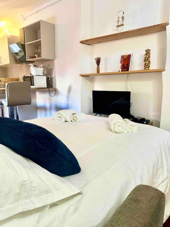 - un grand lit blanc avec des serviettes dans l'établissement Charmant studio Vieux Nice, à Nice