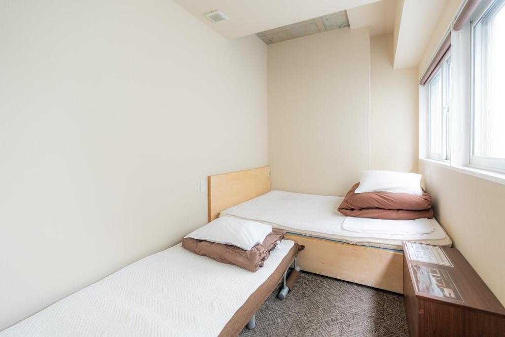Postel nebo postele na pokoji v ubytování Grand Hostel LDK Sapporo