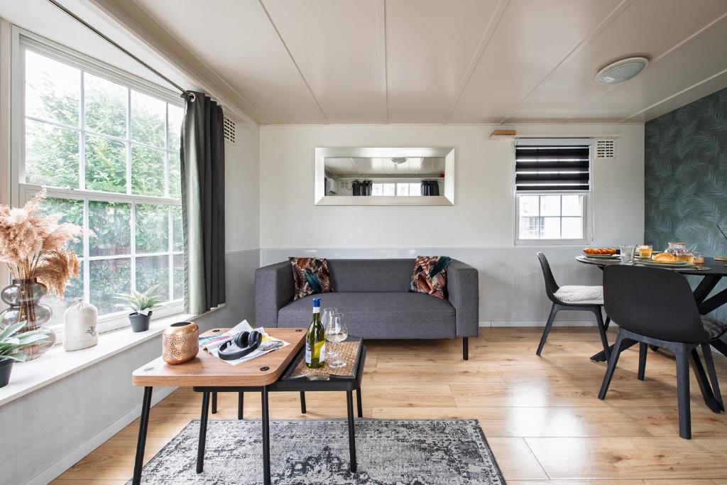 a living room with a couch and a table at 12, Nature, AC, Serenity, Cycling, Hiking & Terraces! in Oisterwijk