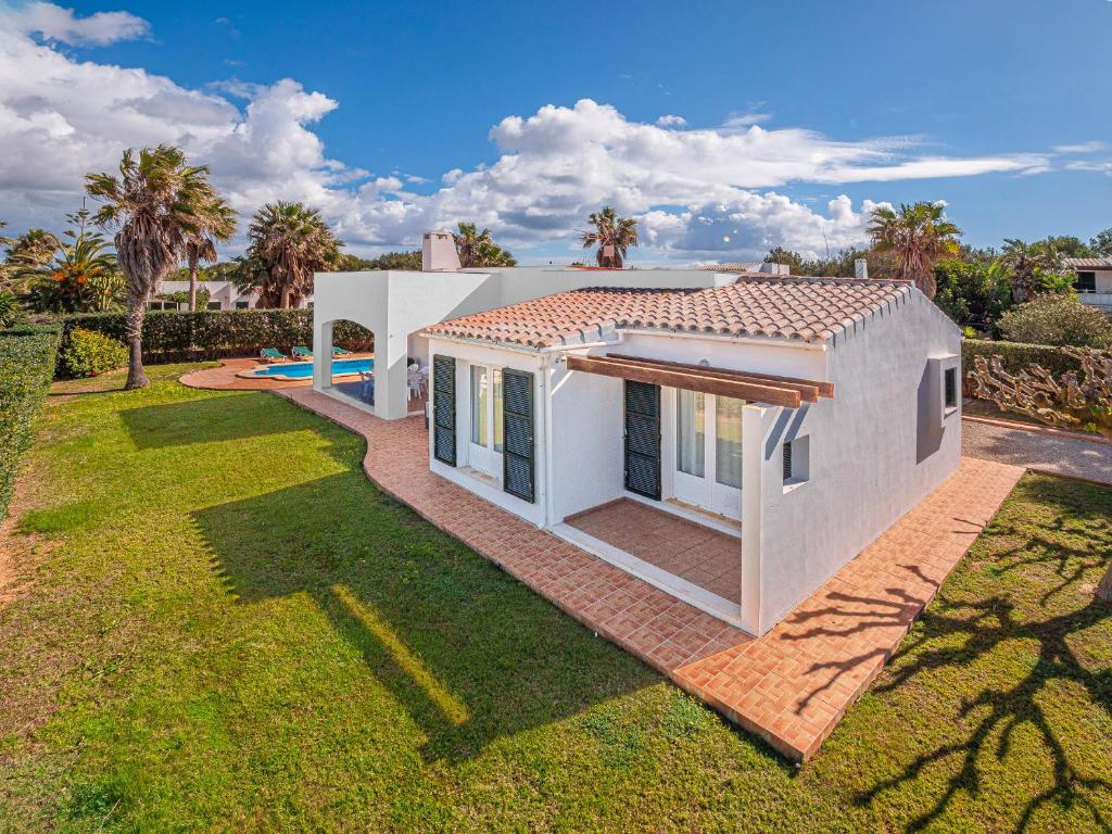 a white house with a lawn in front of it at Kasa K - Slowlife in Binibeca in Binibeca