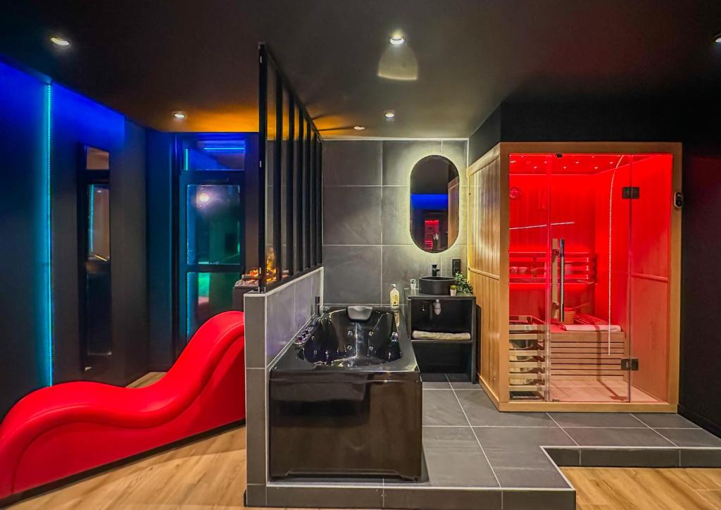La salle de bains est pourvue d'un lavabo et d'une baignoire rouge. dans l'établissement Paradise Sauna Annecy proche du chateau, à Annecy