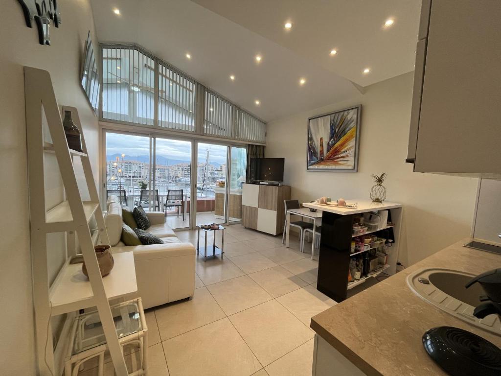 d'une cuisine et d'un salon avec vue sur la ville. dans l'établissement Le Must Cap Hermes, incroyable vue sur port, t2-, à Fréjus