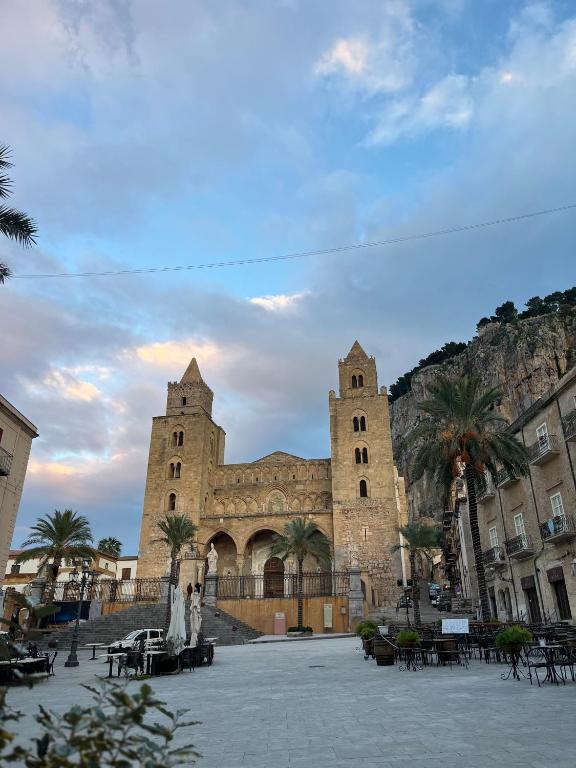 a large building with two towers and palm trees at Spinuzza relax in Cefalù