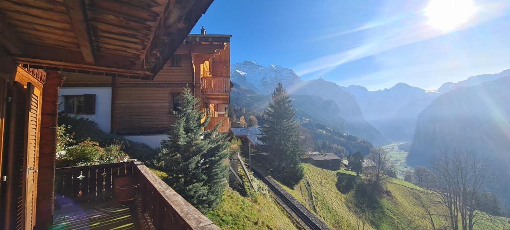 a building with a balcony with a view of a mountain at Chalet am Bluemewäg 7 in Wengen