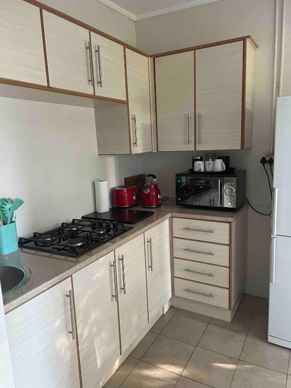 a kitchen with white cabinets and a stove top oven at At 25 Cottage 1 bedroom Balkfontein in Bothaville