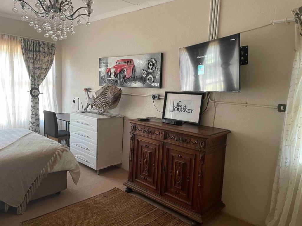 ein Schlafzimmer mit einem Bett und einem Schreibtisch mit Fernseher darauf in der Unterkunft At 25 Cottage 1 bedroom Balkfontein in Bothaville
