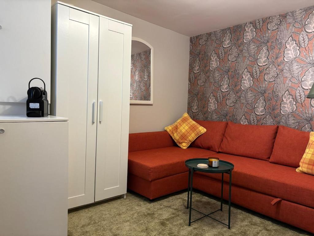 a living room with a red couch and a table at Charming tiny house in The Hague