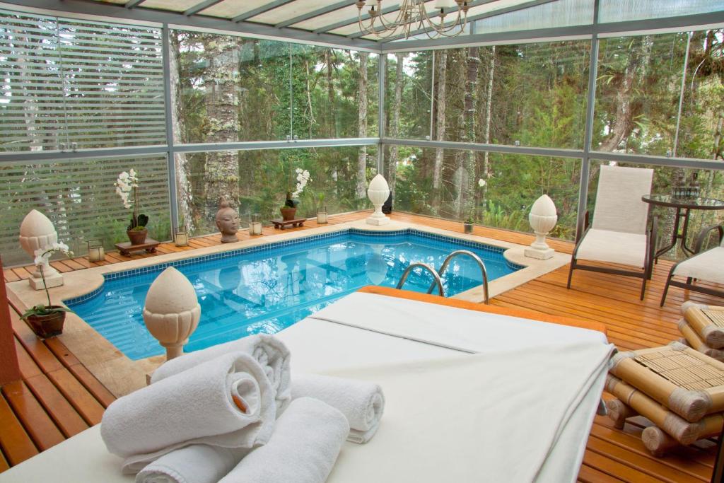 a swimming pool in a room with a large window at Villa Casato Residenza Boutique in Campos do Jordão