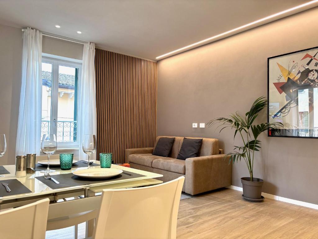 una sala da pranzo e un soggiorno con tavolo e divano. di Residenza Betteloni a Bardolino