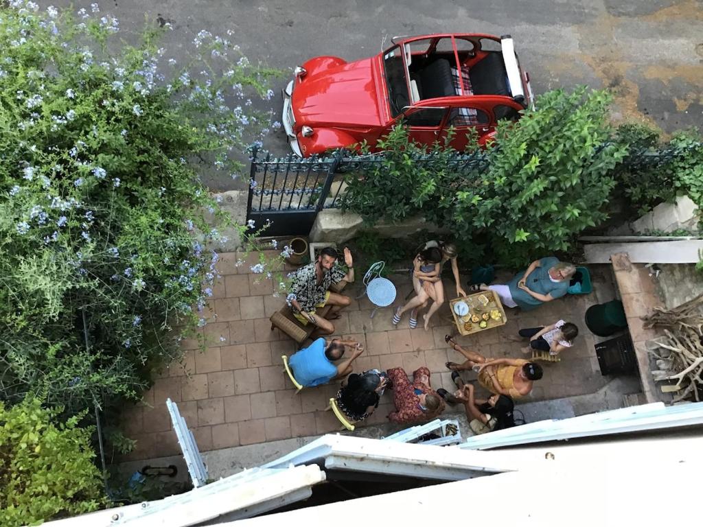 Vue de tête d'un groupe de personnes assises dans une cour dans l'établissement Le Jardinet vacances dans un coin de paradis au bord de la mer, à Peyriac-de-Mer