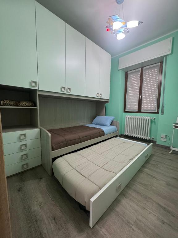 a bedroom with a bed and white cabinets at Casa Alessio - Elegante Appartamento nel Cuore di Cesano Maderno in Cesano Maderno