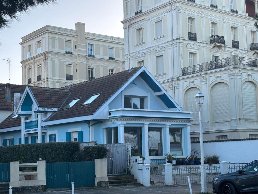 una casa blu di fronte a un grande edificio di 3 pieces avec terrasse entre plage et centre ville ad Arcachon