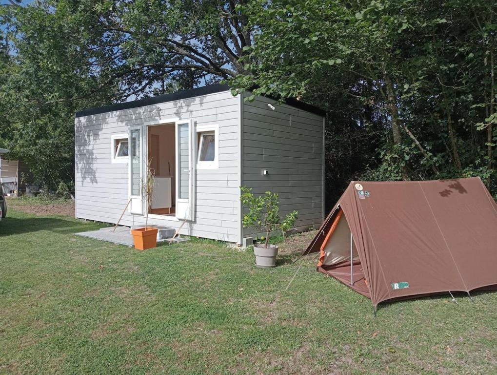 un petit hangar avec une tente dans une cour dans l'établissement Tiny house sous le chene, à Saint-Roch