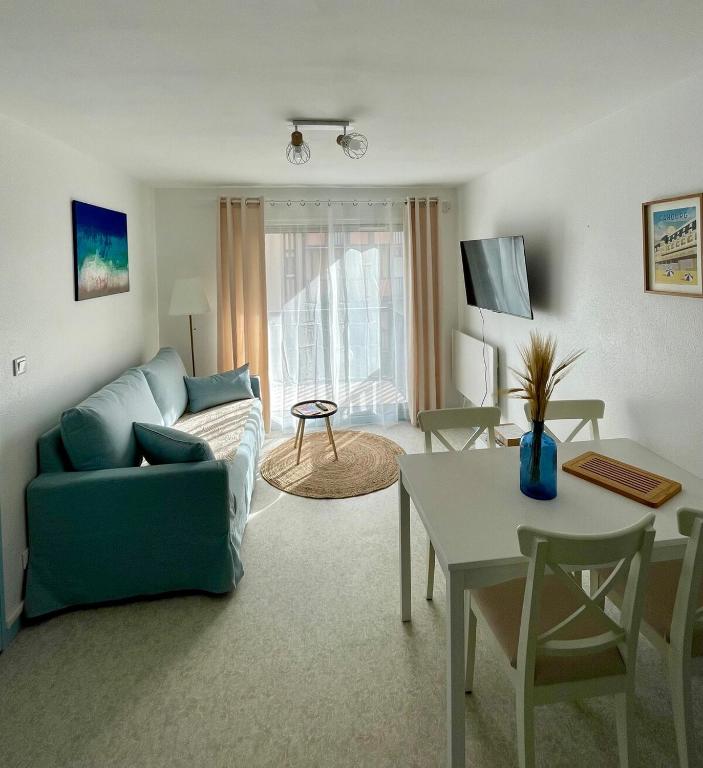 un salon avec un canapé et une table dans l'établissement Appartement 250m mer, 2 vélos avec casques, entièrement rénové en 2025, à Cabourg
