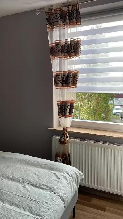 a bedroom with a window with a curtain and a bed at Alios Duren in Düren - Eifel
