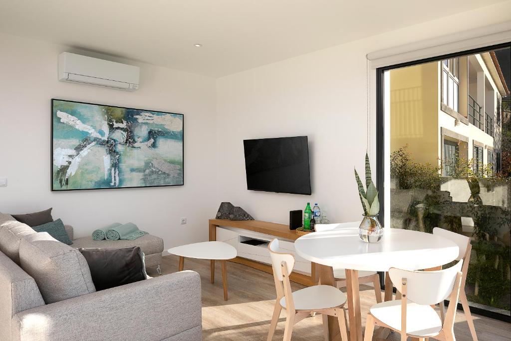 a living room with a couch and a table at Marco 4 Seasons- Winter in Arco da Calheta