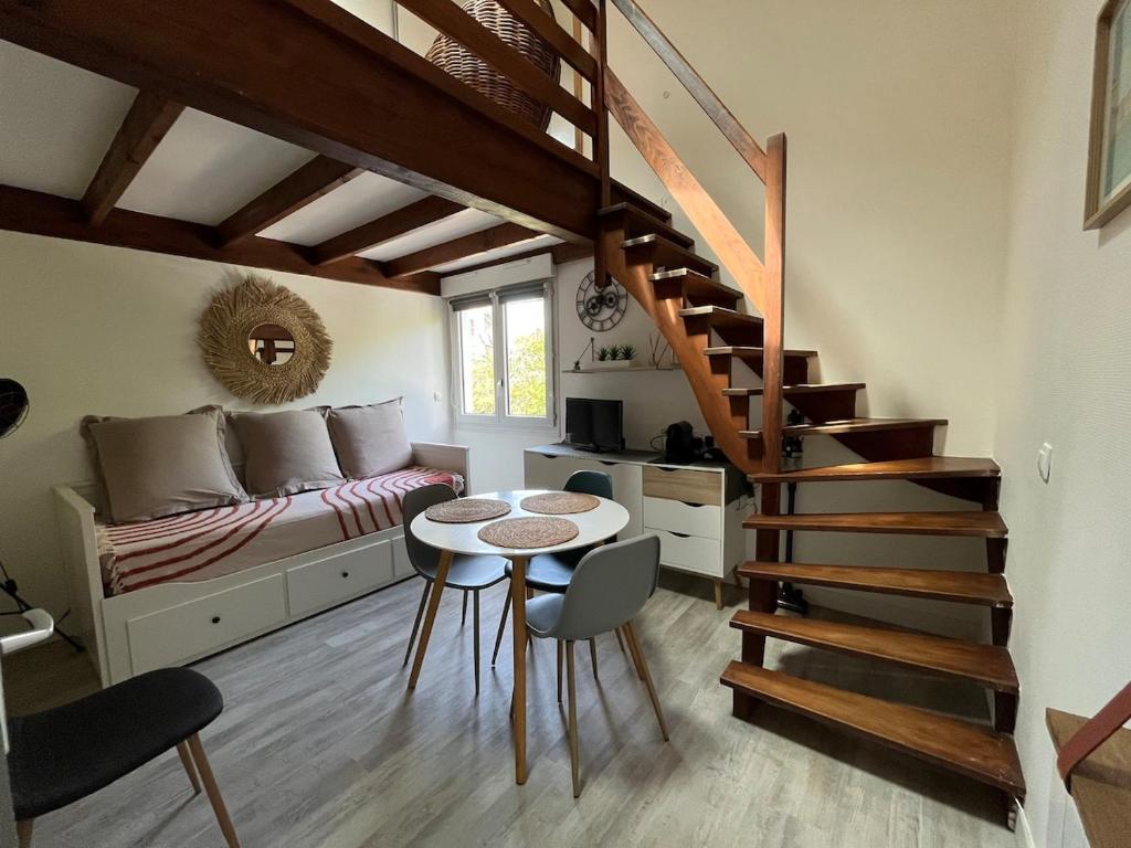 un salon avec un escalier et une table dans l'établissement Appartement proche plage et centre ville, à La Rochelle