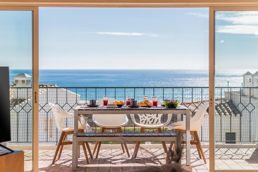 a table on a balcony with a view of the ocean at Casa Londamba Meia Praia Beach in Lagos