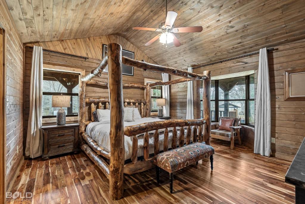 Un dormitorio con una cama y un ventilador de techo. en Hot Tub, Emerald Isle Log Cabin, Lake Front, en Shreveport
