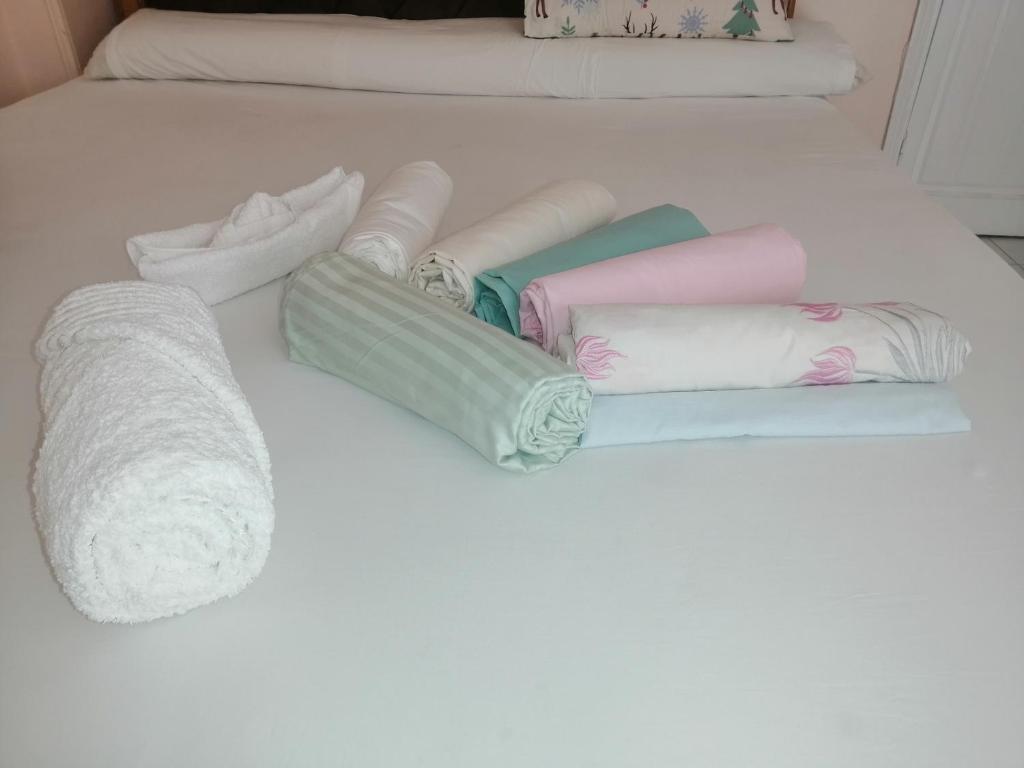un mucchio di asciugamani su un letto bianco di Loyalty apartment a Dumyat al Jadidah