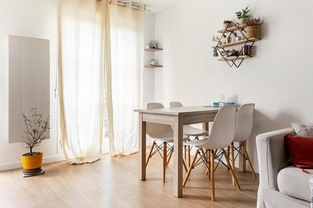 a dining room table and chairs in a living room at Bel appartement calme à Bois-Colombes in Bois-Colombes