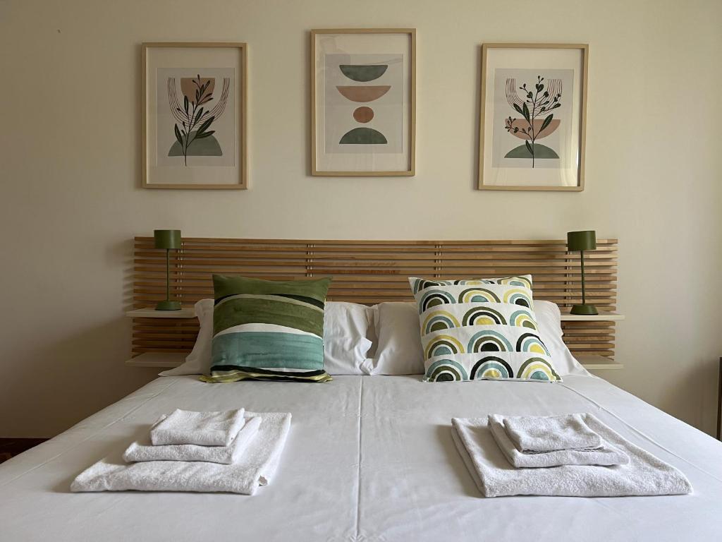 a white bed with two towels on top of it at Casa Margherita (Alba) in Alba