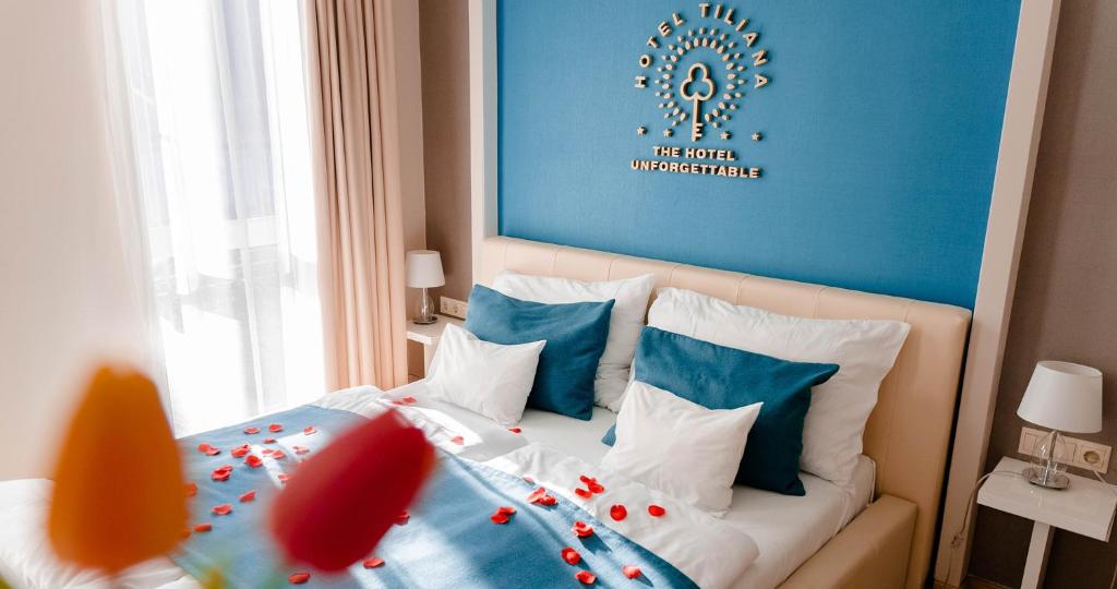 a bedroom with a bed with a blue wall at The Hotel Unforgettable - Hotel Tiliana by Homoky Hotels & Spa in Budapest