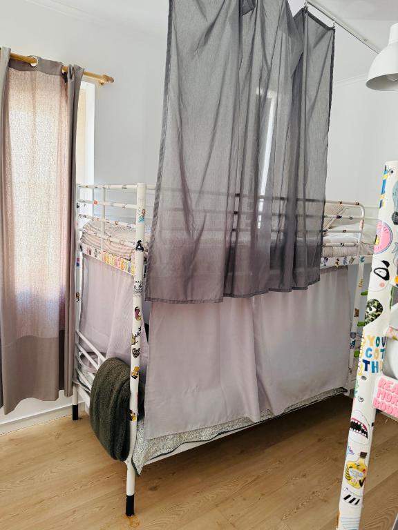 a bunk bed in a room with a curtain at 70's Hostel in Ericeira