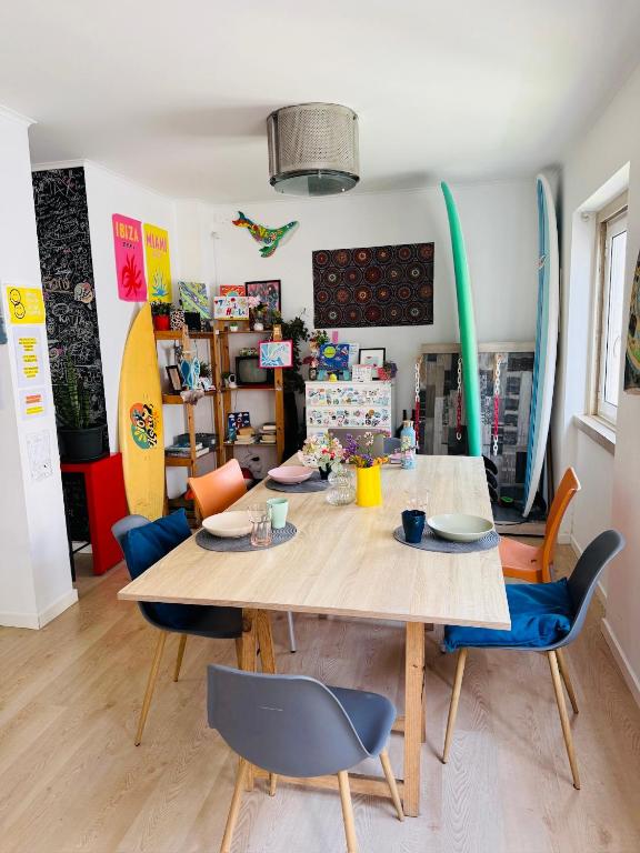 a dining room with a wooden table and chairs at 70's Hostel in Ericeira