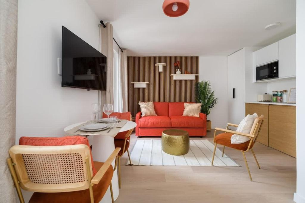 un salon avec un canapé rouge et une table dans l'établissement SERENERS - Charming Serviced Apartments - Saint Germain, à Paris