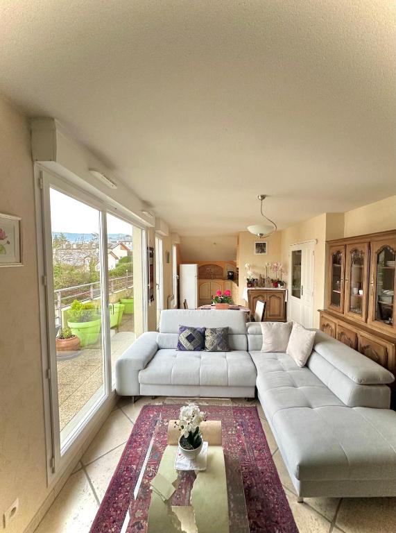 un salon avec un canapé et une table dans l'établissement Appartement vue sur le Chateau, à Vétraz-Monthoux