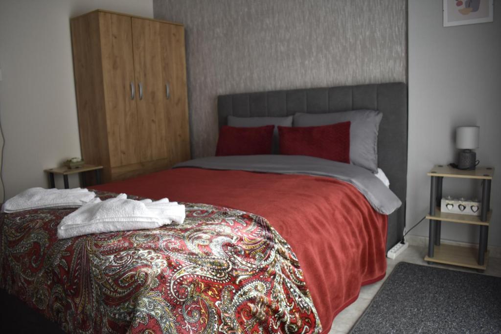a bedroom with a large bed with a red blanket at Floor in Alexandroupoli