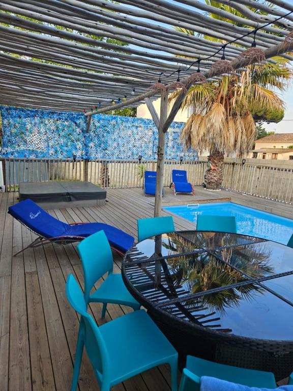 une terrasse avec des chaises, une table et une piscine dans l'établissement La Villa des Lions, au Grau-dʼAgde