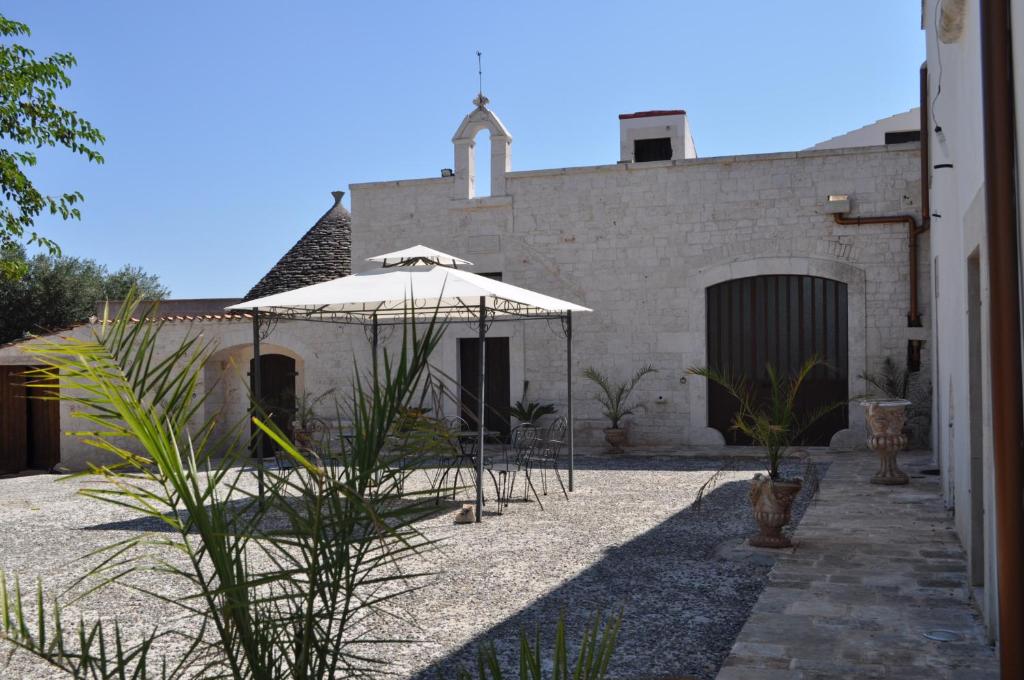 a patio with an umbrella in front of a building at Masseria Costanza in Putignano