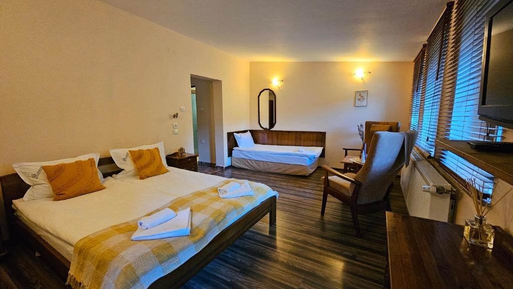a bedroom with a bed and a living room at Hotel Izvorat Arda - Хотел Изворът Арда in Arda